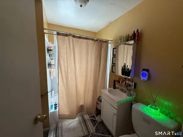 a bathroom with a sink toilet and shower curtain