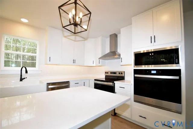 a kitchen with stainless steel appliances a stove a sink and a microwave