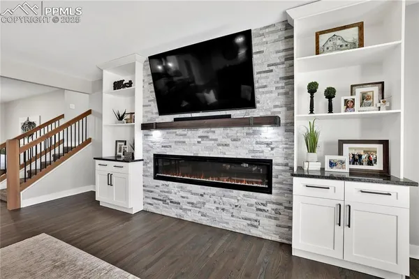 a living room with furniture a flat screen tv and a fireplace