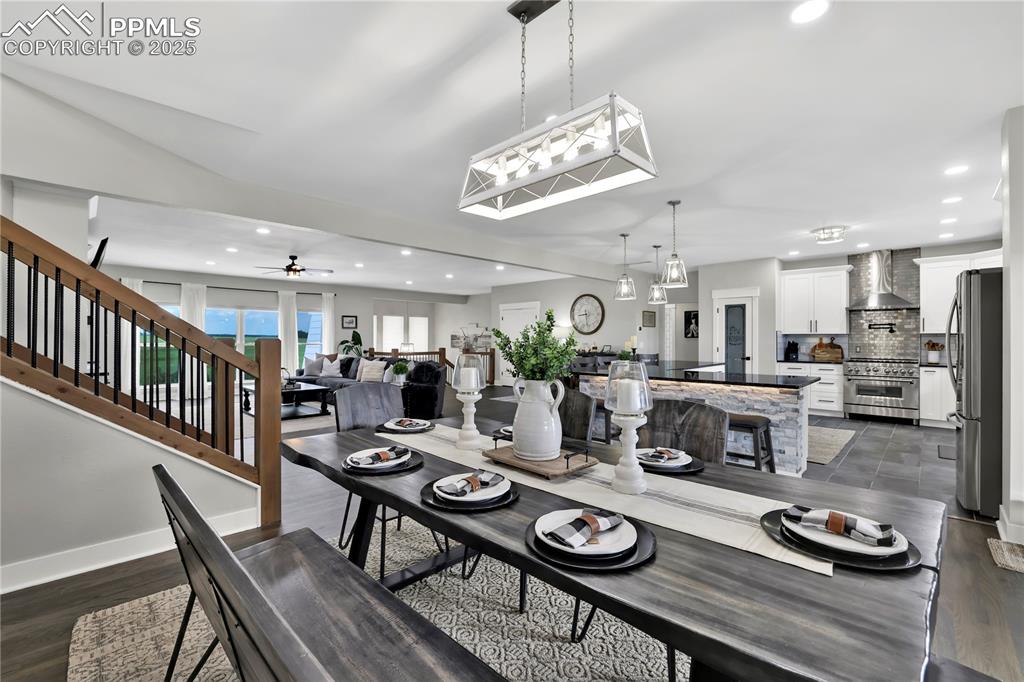 18135 Spur Ranch Road Peyton, CO 80831 - Photo 15 of 36 a view of a dining room with furniture a chandelier and wooden floor