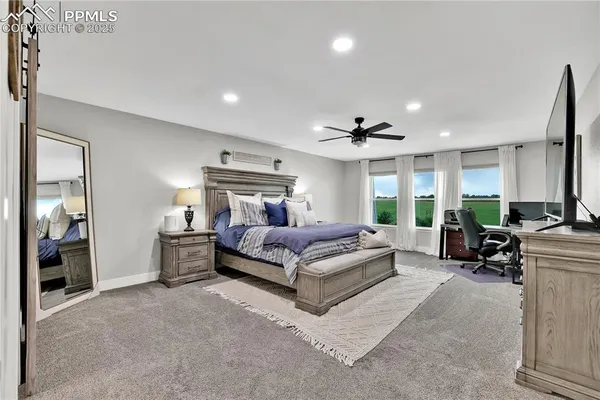 a spacious bedroom with a bed a table and large window