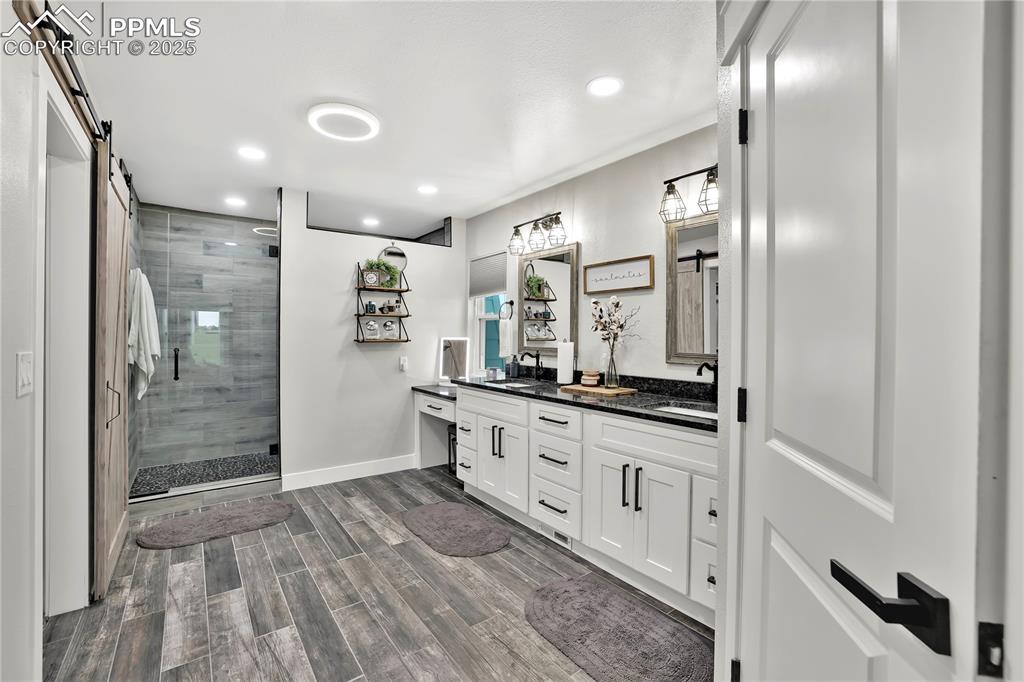 18135 Spur Ranch Road Peyton, CO 80831 - Photo 19 of 36 a bathroom with double vanity and a shower