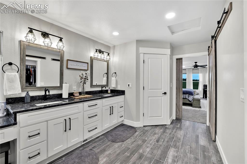 18135 Spur Ranch Road Peyton, CO 80831 - Photo 20 of 36 a spacious bathroom with a granite countertop sink mirror and a