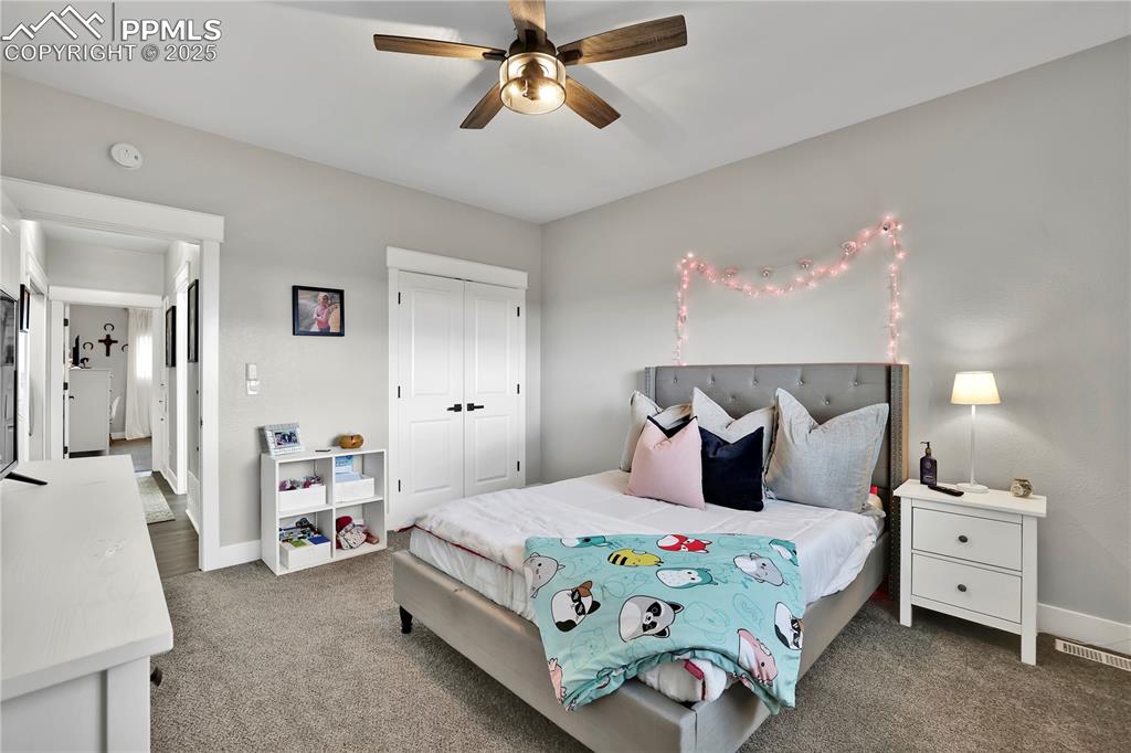 18135 Spur Ranch Road Peyton, CO 80831 - Photo 23 of 36 a bedroom with a bed and a chandelier