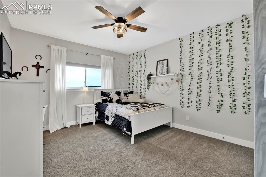 18135 Spur Ranch Road Peyton, CO 80831 - Photo 24 of 36 a spacious bedroom with a bed and a window