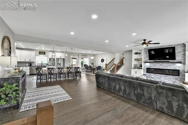 a living room with furniture a flat screen tv and kitchen view