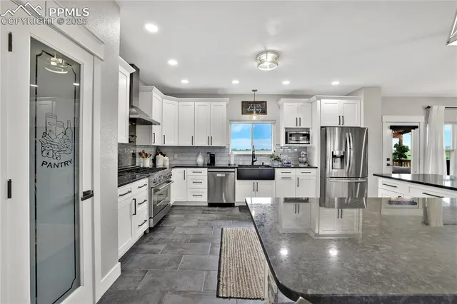 a kitchen with stainless steel appliances granite countertop a refrigerator sink and cabinets