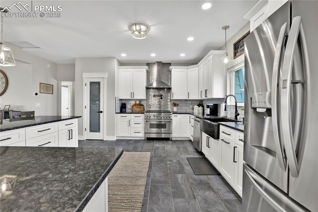 18135 Spur Ranch Road Peyton, CO 80831 - Photo 9 of 36 a kitchen with stainless steel appliances granite countertop a refrigerator sink and white cabinets