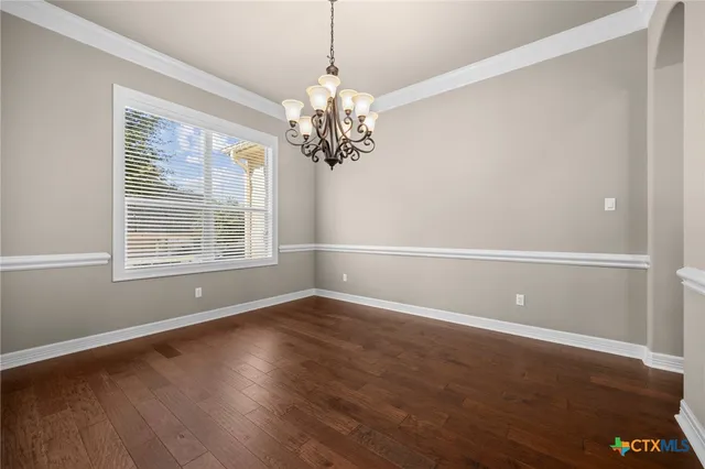 an empty room with fireplace wooden floor and windows