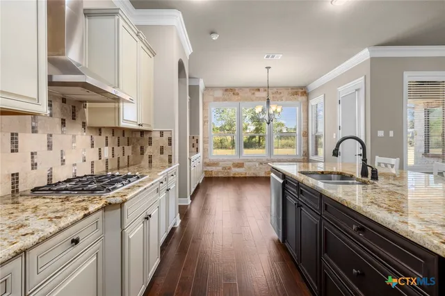 an empty room with wooden floor a ceiling fan a fireplace and windows