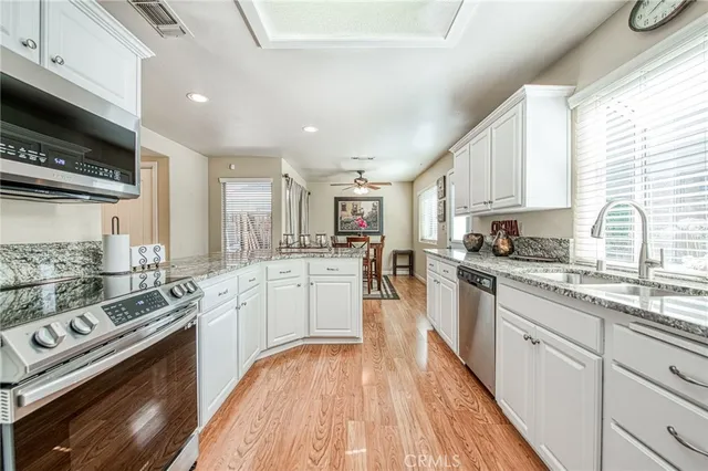 a kitchen with stainless steel appliances granite countertop a stove a sink dishwasher and a refrigerator