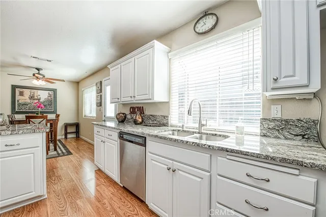 a kitchen with granite countertop white cabinets and white appliances