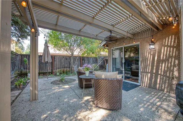 a view of a patio with table and chairs potted plants with floor to ceiling window