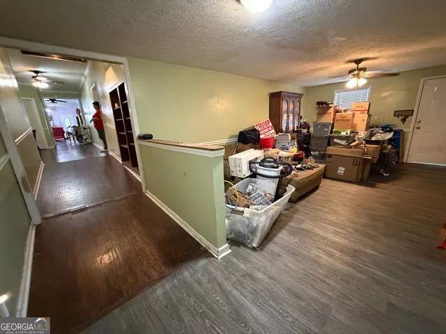 a room with a black white checkered floor with a gaming machine and dining table
