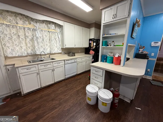 a kitchen with a sink and a stove with wooden floor