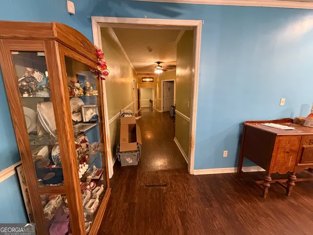 a view of a hallway with wooden floor and furniture