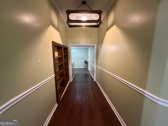 a view of a hallway with wooden floor and staircase