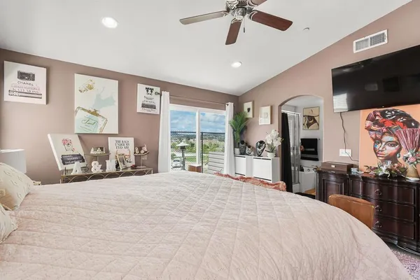 a large bedroom with a bed and a flat screen tv