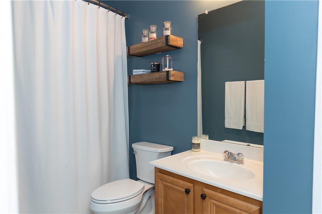 502 Streamside Place Canton, GA 30115 - Photo 14 of 33 a bathroom with a sink a toilet and shower curtain