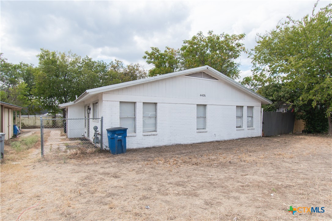 a front view of house with yard and trees in the background