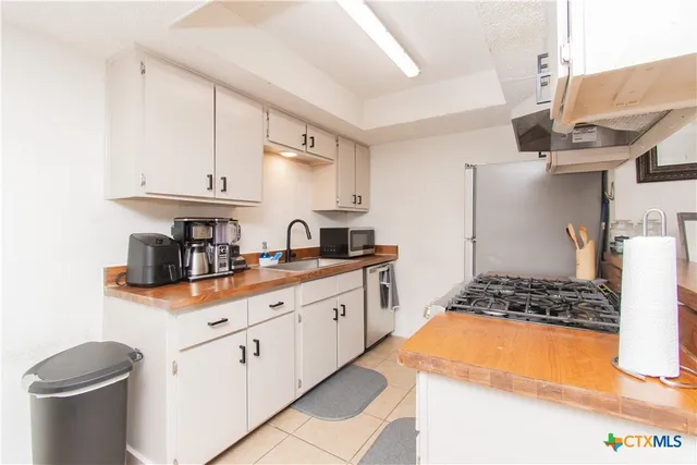 a kitchen with granite countertop a sink stove and cabinets