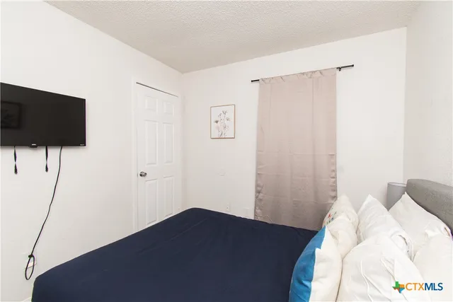 a bedroom with a bed and a flat screen tv