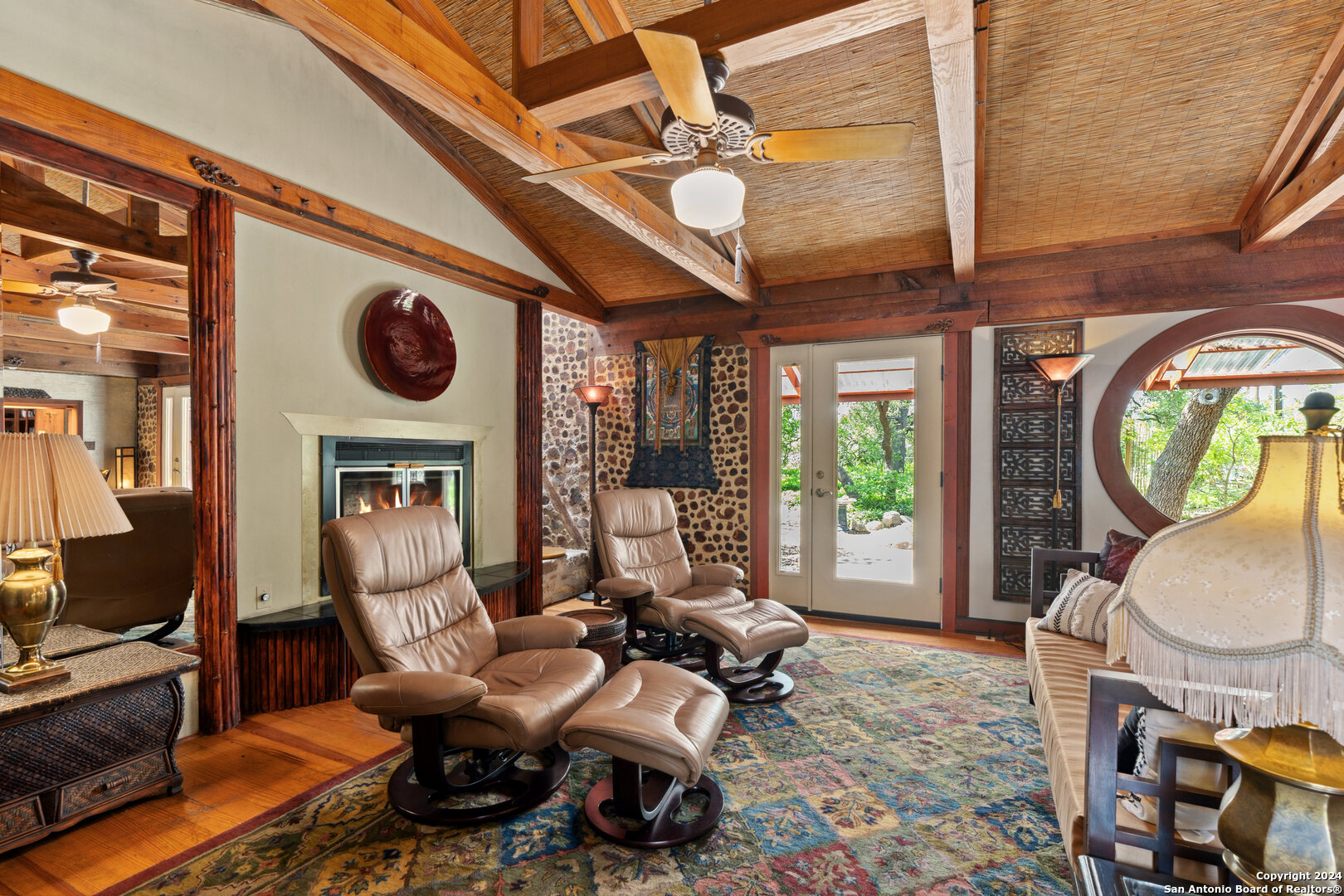 801 Mickle Creek Road Medina, TX 78055 - Photo 14 of 55 a living room with furniture a fireplace a clock and a large window