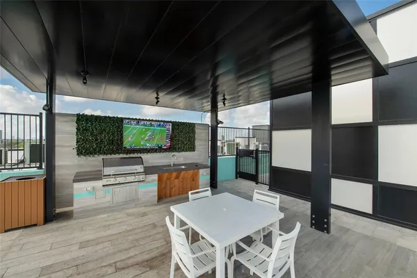 a kitchen with stainless steel appliances kitchen island granite countertop a refrigerator a stove and a wooden floors