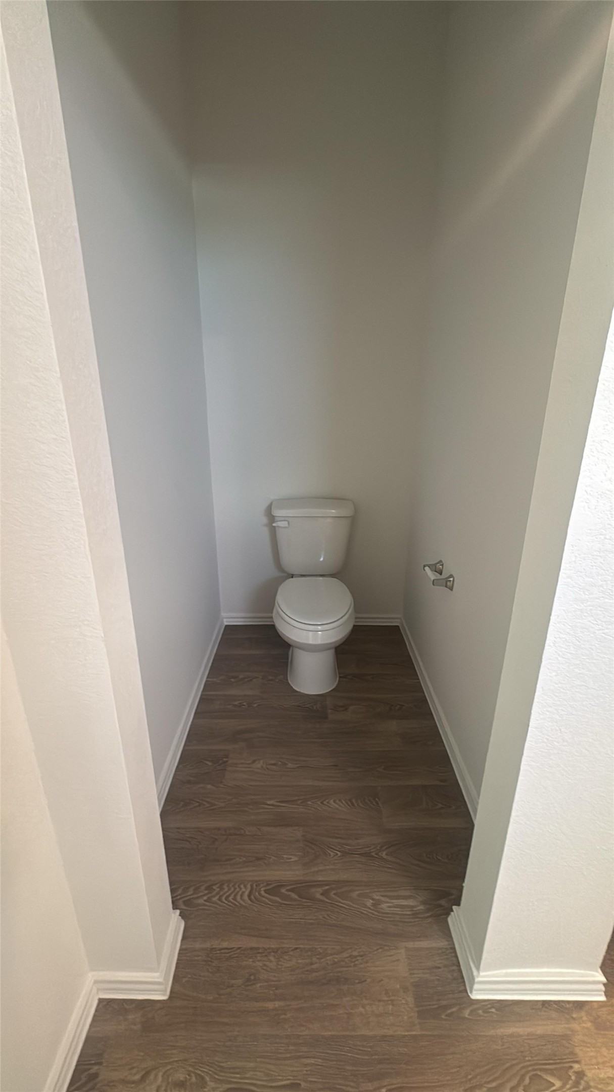 174 Balmorhea Street Kyle, TX 78640 - Photo 24 of 29 A private water closet features rich hardwood flooring and pristine white walls.