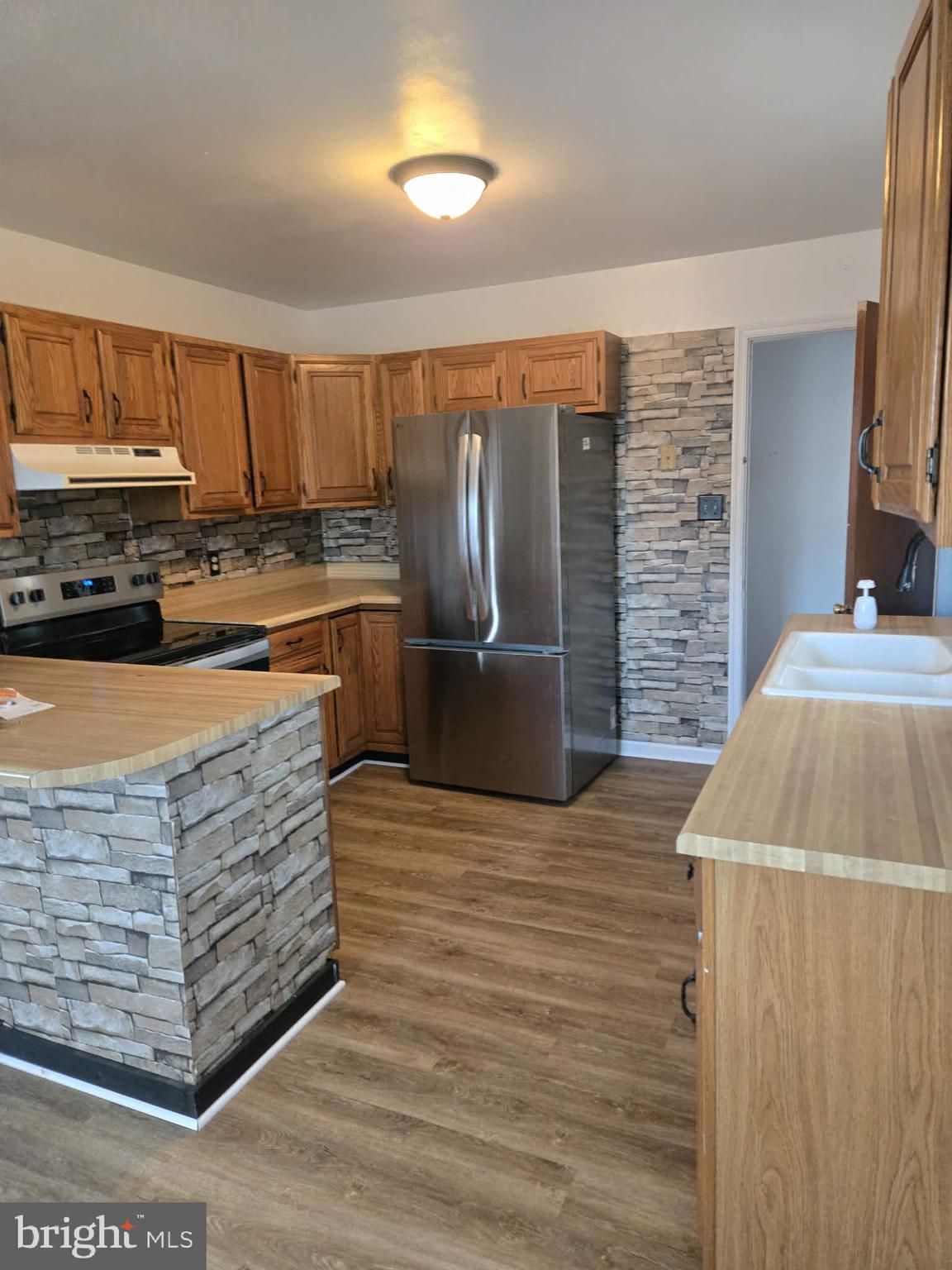 306 Ryan Drive Rising Sun, MD 21911 - Photo 5 of 23 a kitchen with stainless steel appliances granite countertop a refrigerator a stove and a sink with wooden cabinets
