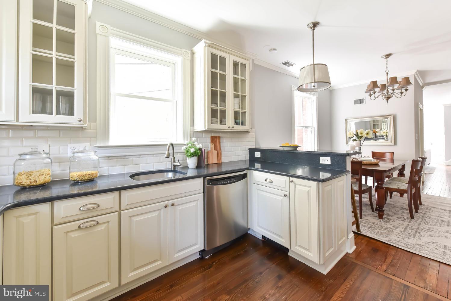 308 11th Street Southeast Washington, DC 20003 - Photo 13 of 30 a kitchen with granite countertop white cabinets and white appliances