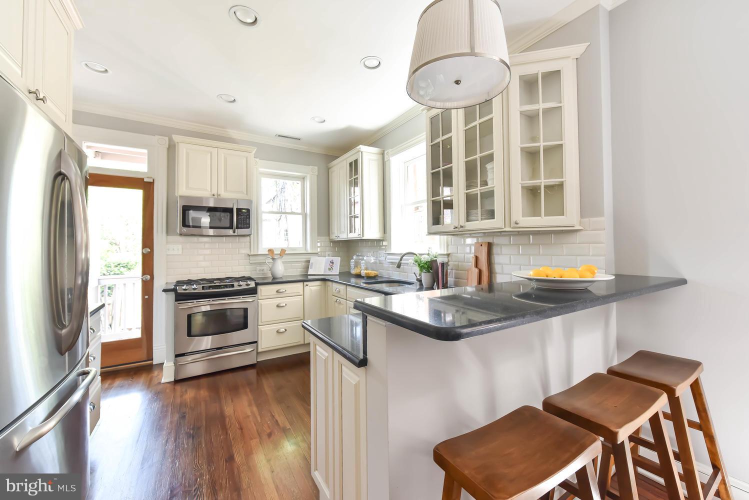 308 11th Street Southeast Washington, DC 20003 - Photo 7 of 30 a kitchen with stainless steel appliances kitchen island granite countertop a stove a sink and a refrigerator