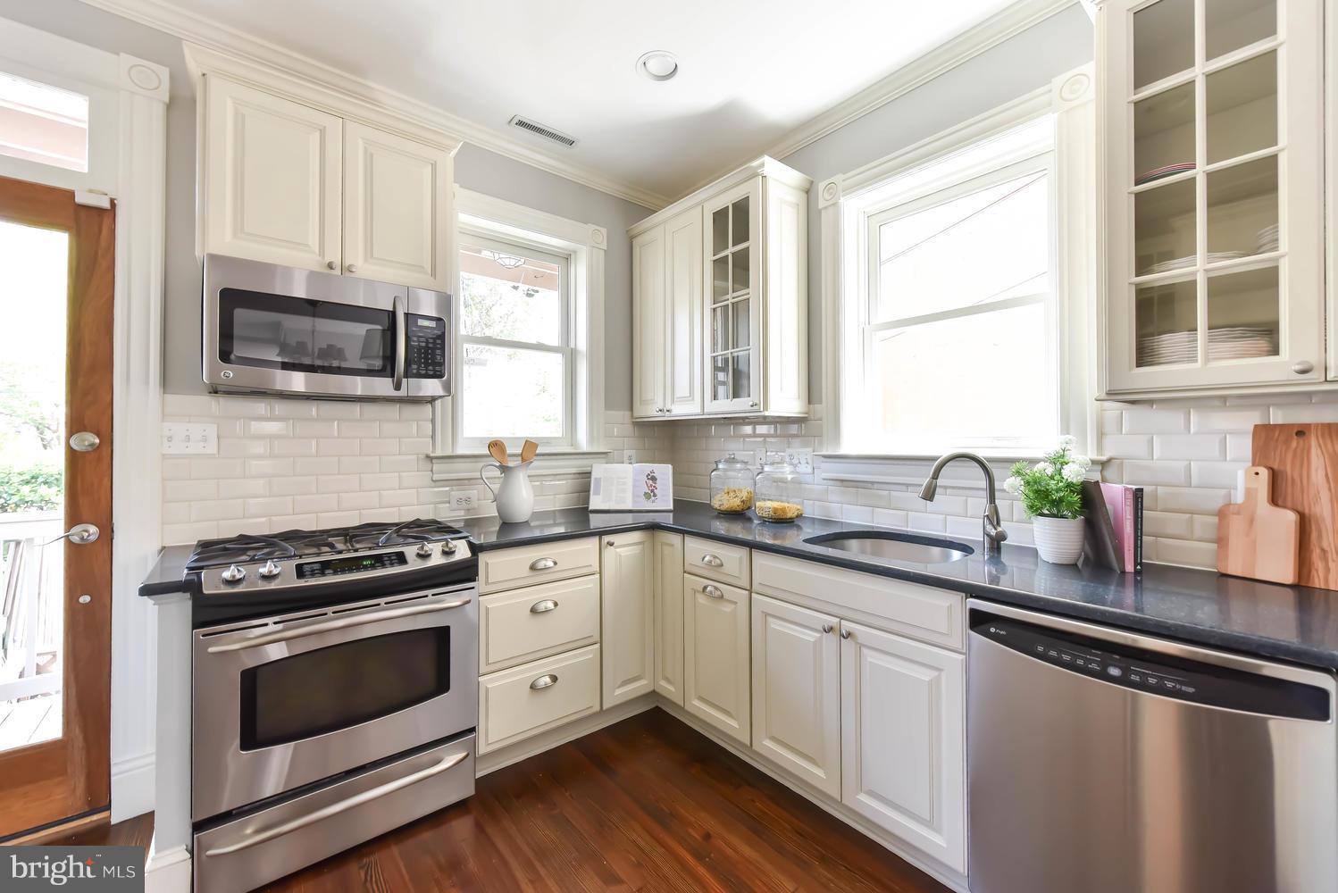 308 11th Street Southeast Washington, DC 20003 - Photo 8 of 30 a kitchen with stainless steel appliances a stove sink microwave and cabinets