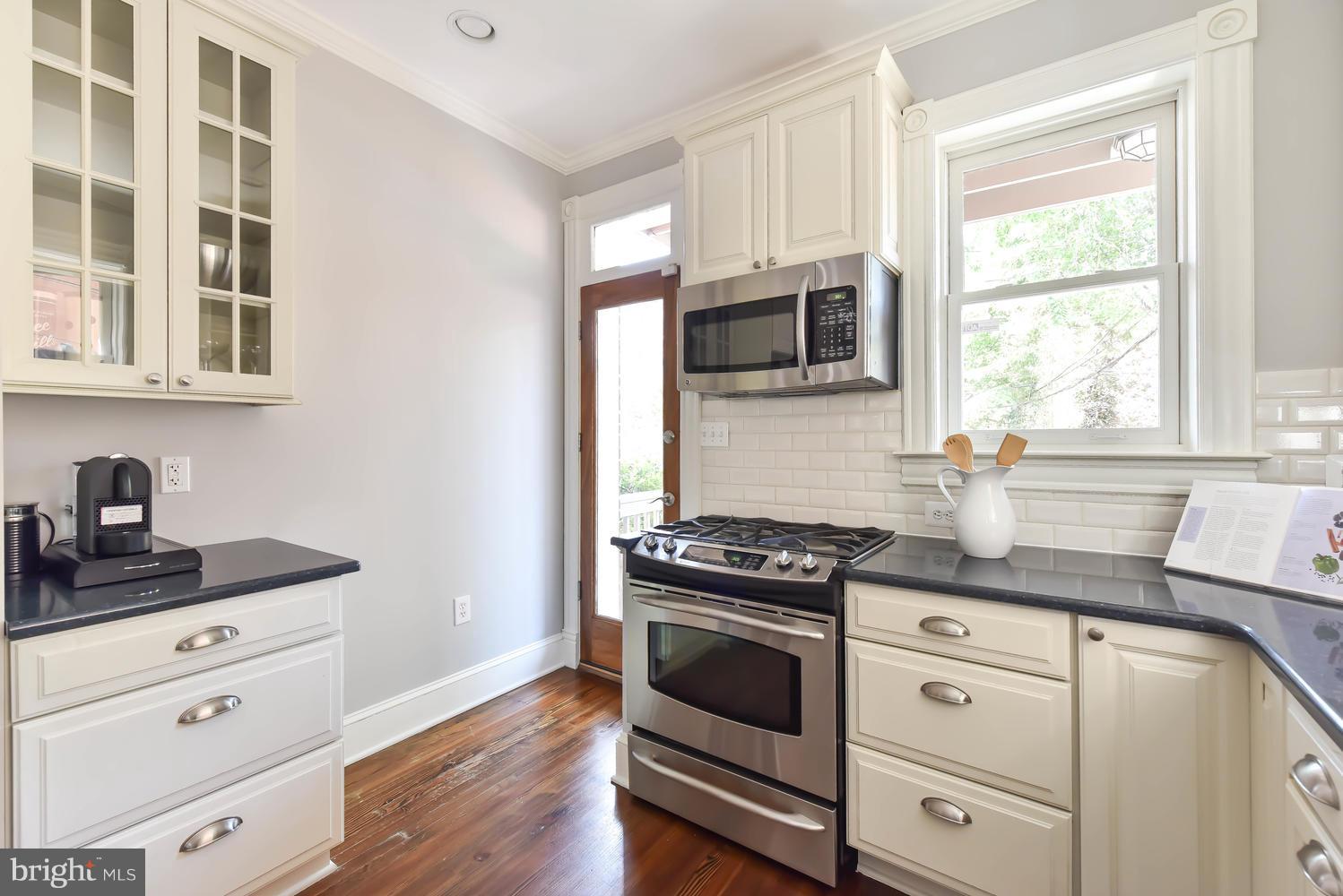 308 11th Street Southeast Washington, DC 20003 - Photo 9 of 30 a kitchen with granite countertop a stove a sink and wooden floor
