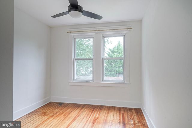 an empty room with a window and wooden floor