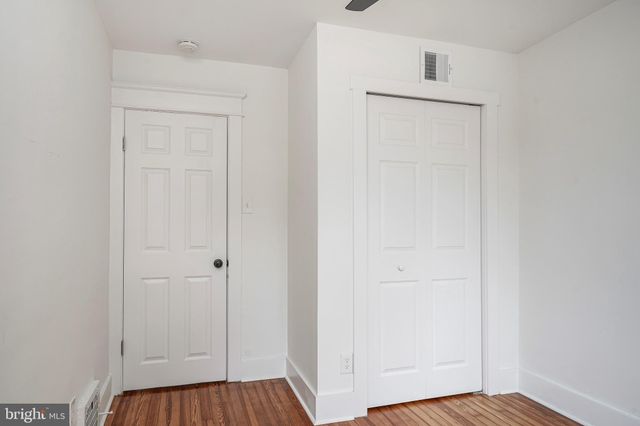 an empty room with wooden floor and closet