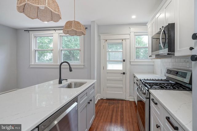 a kitchen that has a sink stainless steel appliances a window and a counter top space