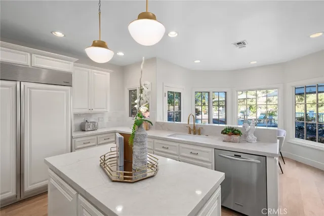 a kitchen with sink a refrigerator and windows