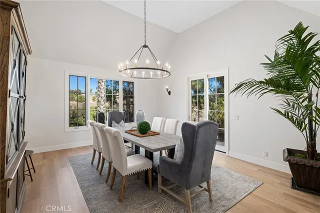 a dining room with furniture a chandelier and wooden floor