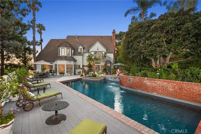 a view of a house with pool lawn chairs and a fire pit
