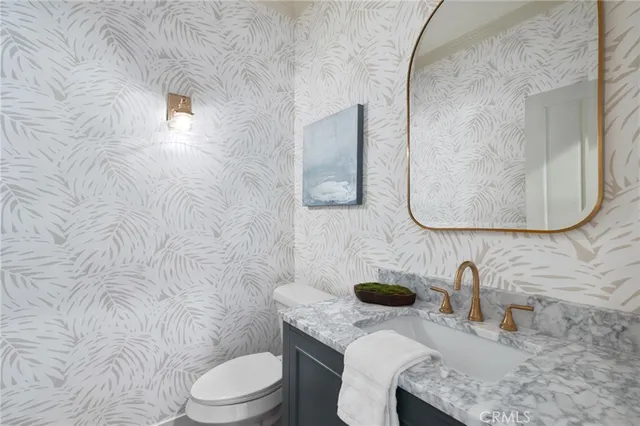 a bathroom with a granite countertop toilet sink and mirror