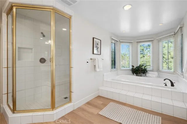 a spacious bathroom with a tub shower and window