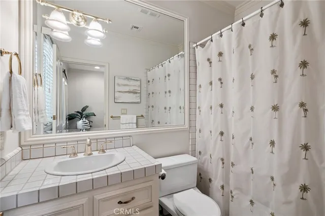 a bathroom with a granite countertop sink a toilet and a mirror