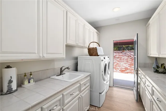 a utility room with sink dryer and washer