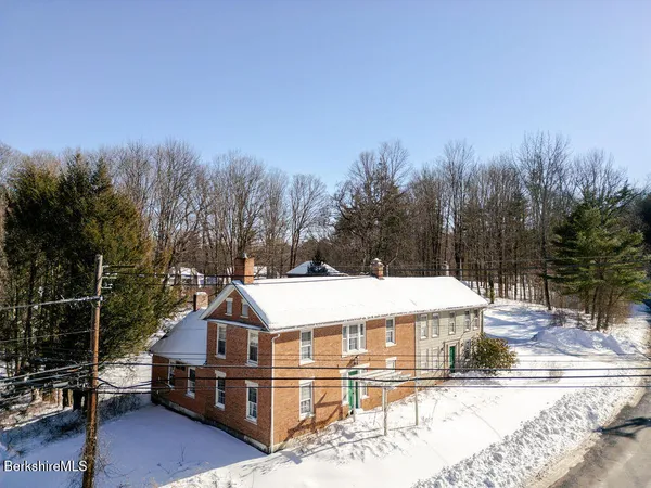 a view of a house with a yard covered in snow