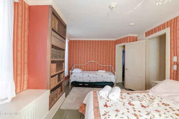 a bedroom with two beds and large closet