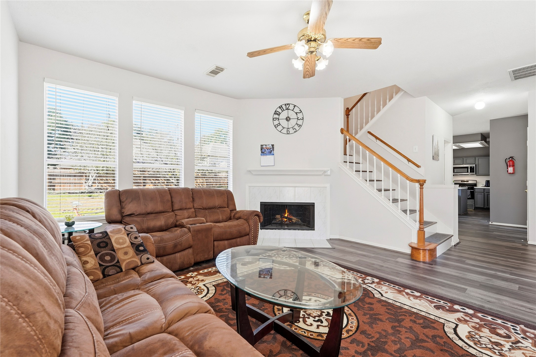 8706 Lone Maple Drive Houston, TX 77083 - Photo 10 of 27 a living room with furniture a fireplace and a chandelier