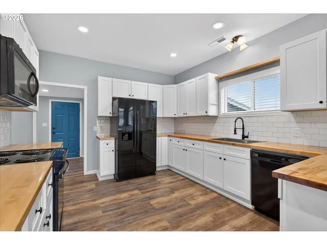 a kitchen with stainless steel appliances granite countertop a refrigerator a sink dishwasher a stove with wooden cabinets