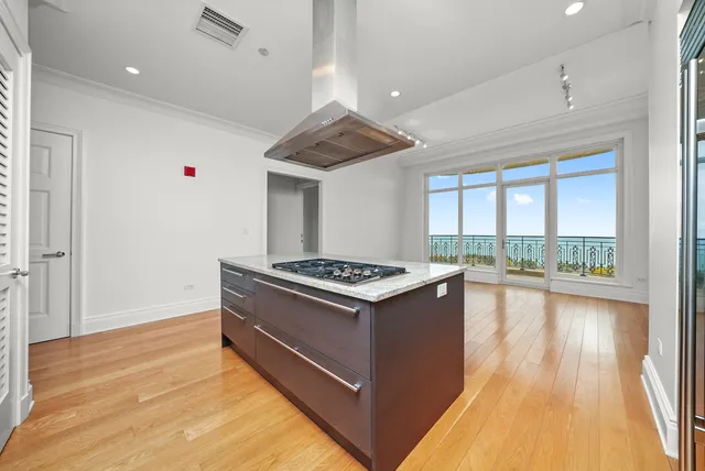 a kitchen with stainless steel appliances granite countertop a stove and a wooden floors