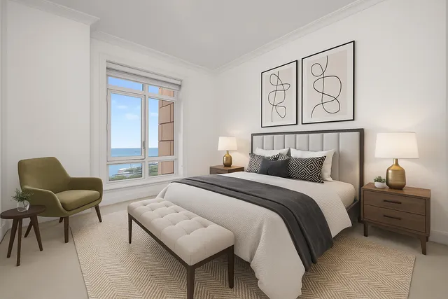 a bedroom with a bed and chair with window